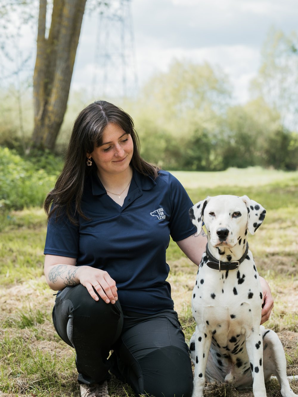 Ashley, éducatrice canine, accroupie près d'un dalmatien lors d'une séance